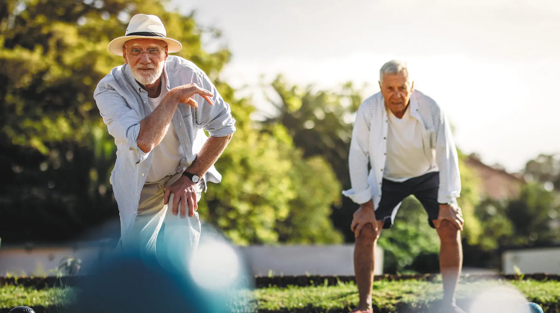 Senior man throwing a boules standing in position