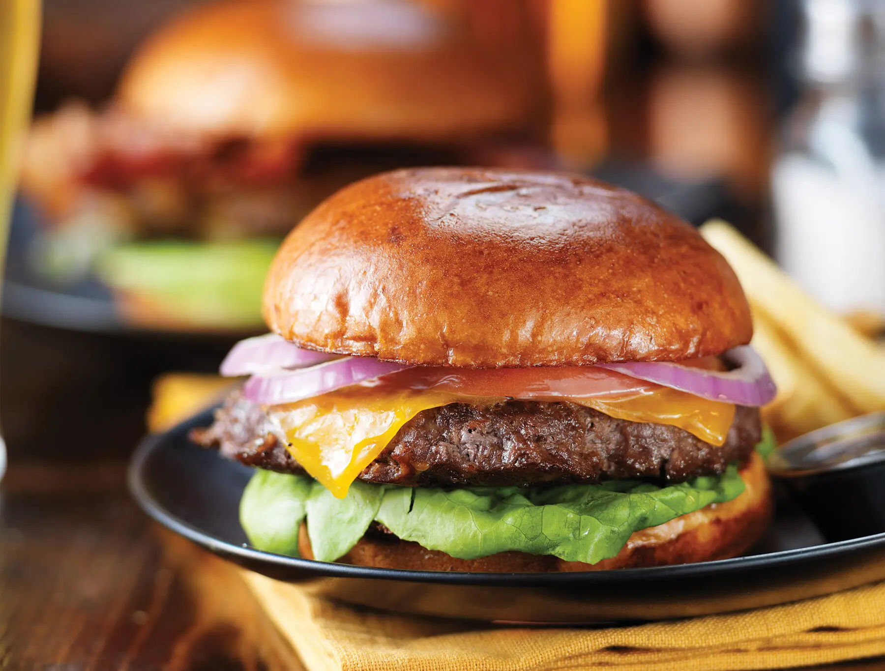 Cheeseburgers and fries on table top